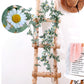 Artificial flower vine with white daisy blossoms and green leaves on a birch-style frame