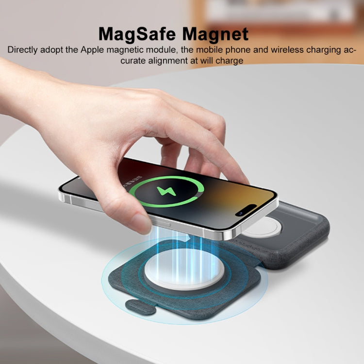 Gray foldable wireless charger with MagSafe magnet aligning a smartphone