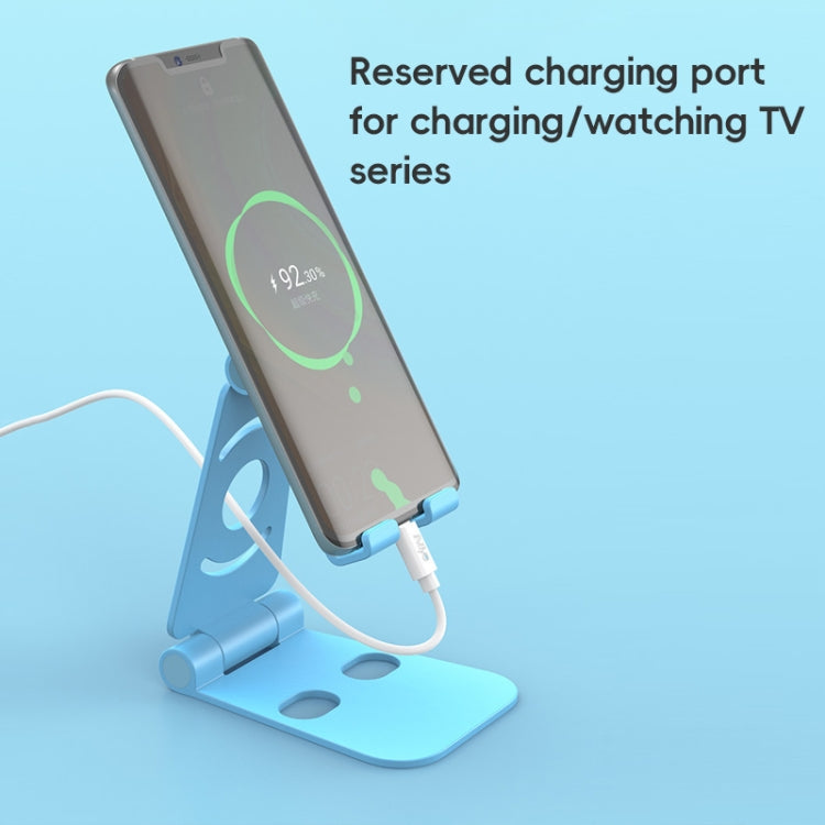 Foldable phone stand, light blue, holding a phone with charging cable connected