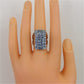 Blue crystal rectangular ring on finger, silver-tone openwork band