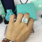 Silver rhinestone square ring worn on a hand, center stone visible