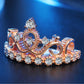 Rose gold crown-shaped zircon ring with central oval stone and round stones across band