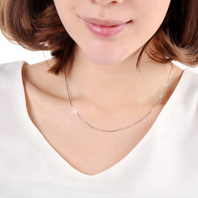 Silver snake-bone chain necklace worn with V-neck top, 38 in length