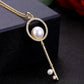 Gold key pendant necklace with circular pearl, rhinestone border, and hanging key charm