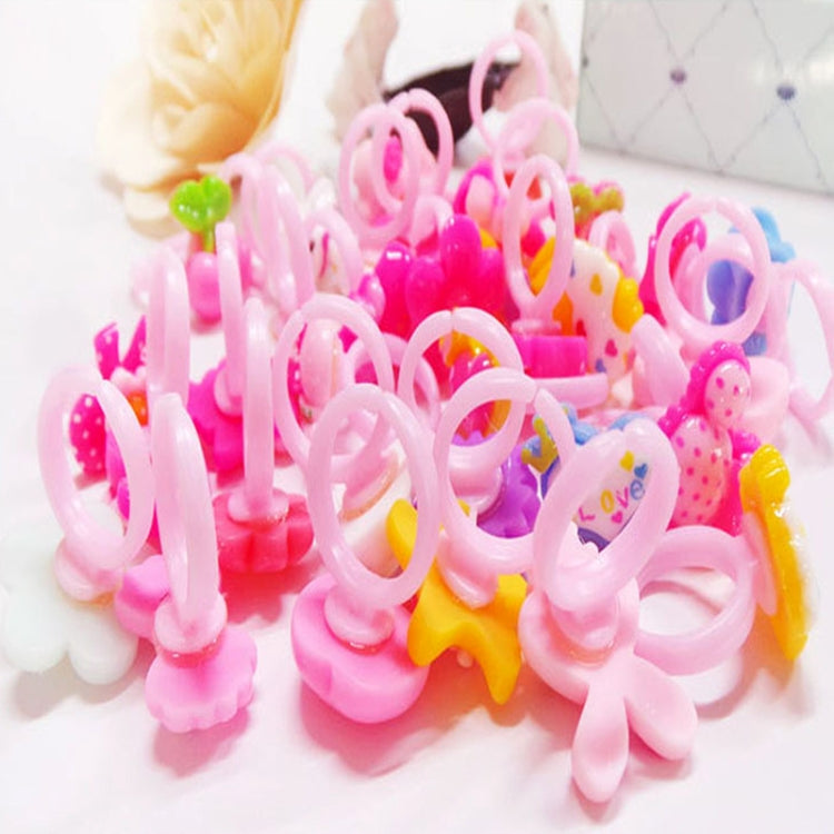 Close-up of pink resin kids character rings with loop bands and bow-and-flower charms