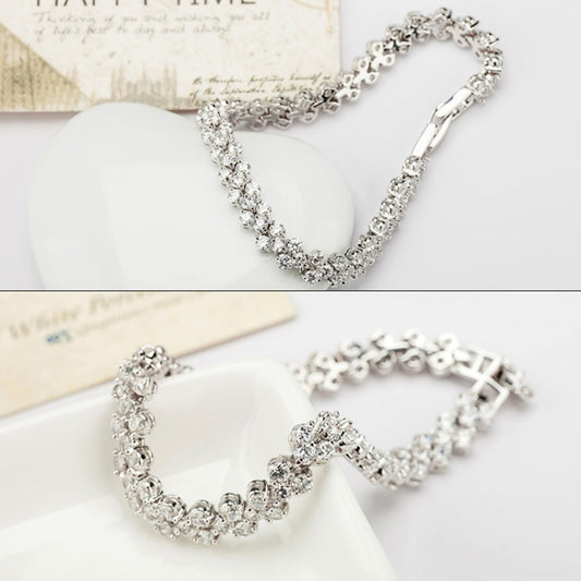 Platinum-tone rhinestone tennis bracelet worn on hand, round crystal stone row