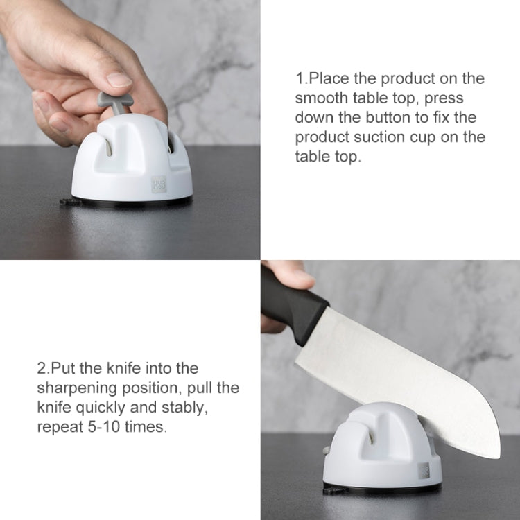 White double-wheel knife sharpener with suction base in use on a table