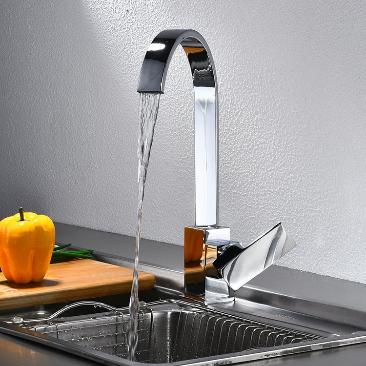 Chrome sink mixer faucet with arched spout and running water over the basin