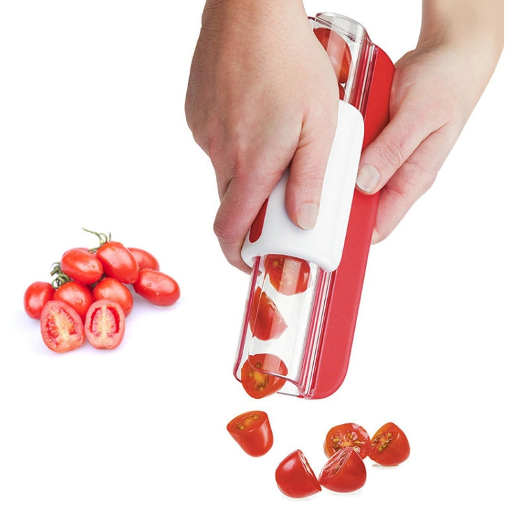 Cherry tomato slicer tool with red and white handle and clear cutting chamber