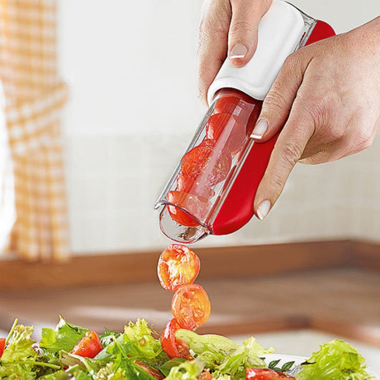 Handheld red and white cherry tomato slicer releasing sliced pieces into food