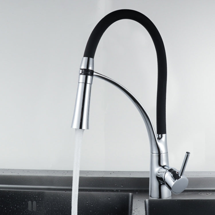 Pull-out kitchen faucet with black-and-chrome spout spraying water from the hose