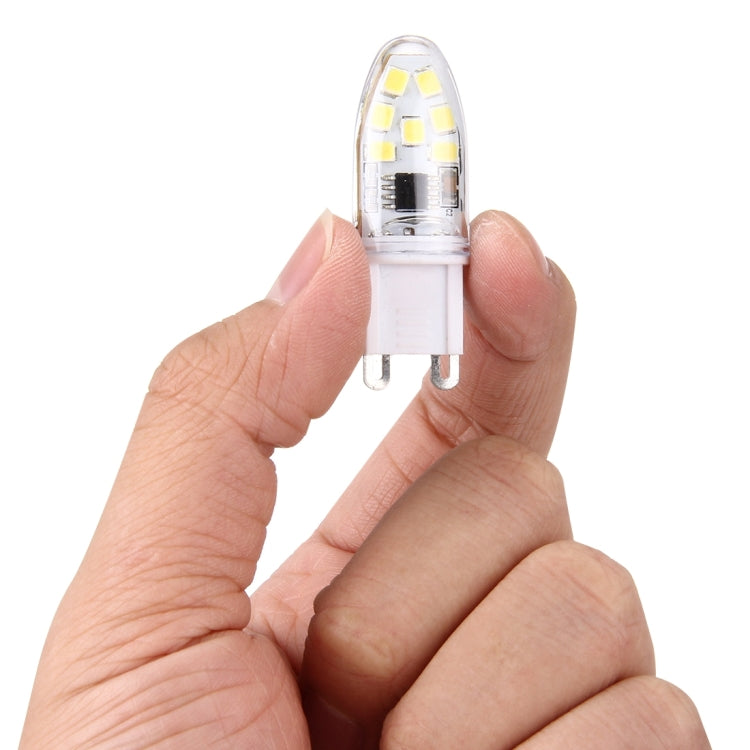 Dimmable LED G9 bulb held in hands, clear capsule with 14 SMD LEDs