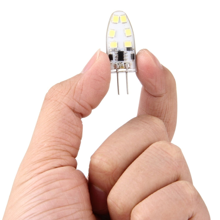 Small clear 12-SMD LED capsule module with two pins held in hand