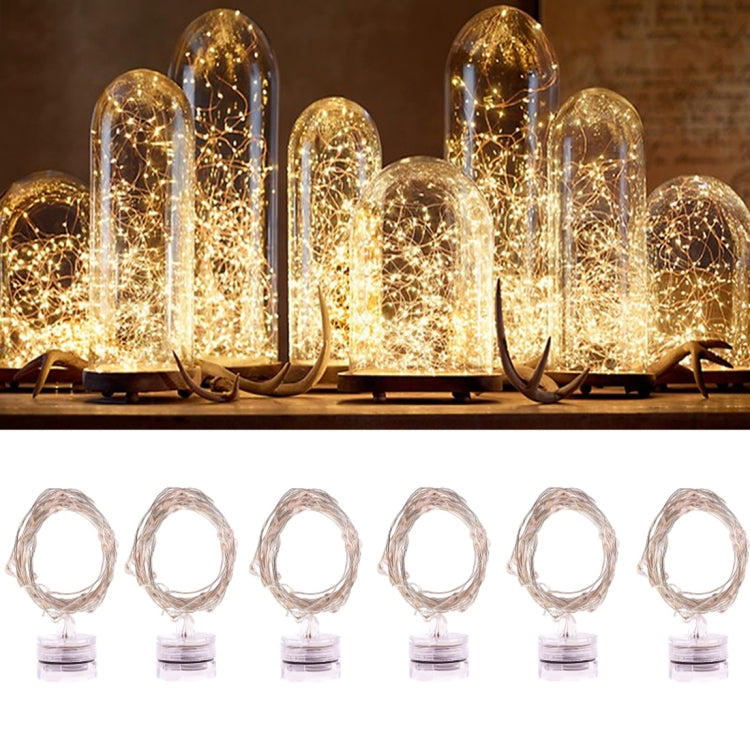 Warm white LED rope fairy lights with lit glass tube bulbs on the ground
