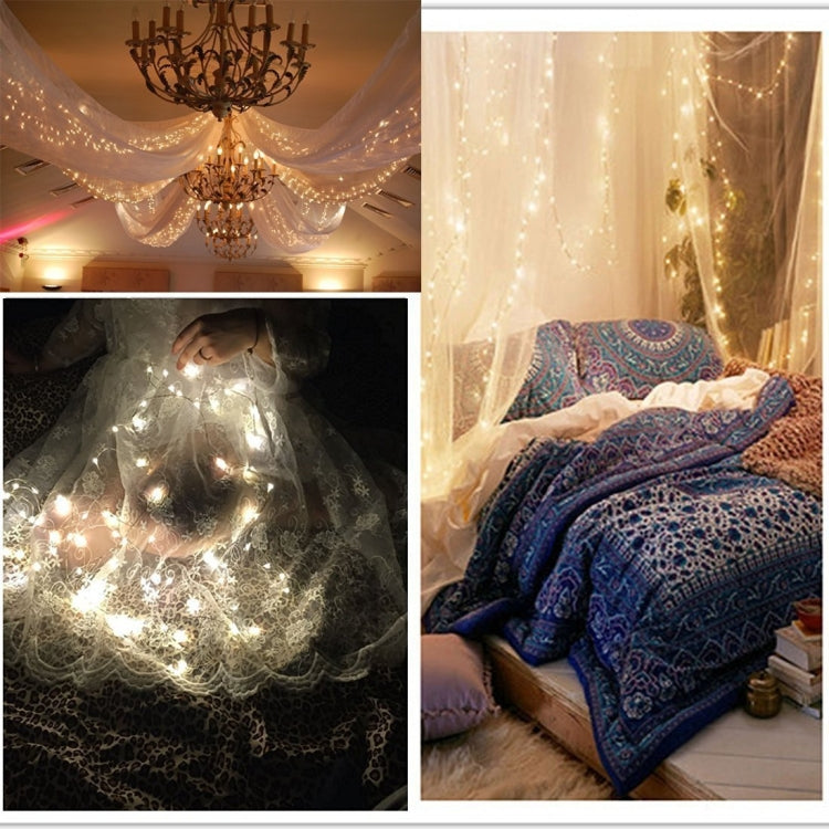 Warm white LED rope fairy lights draped across ceiling and covering bedding