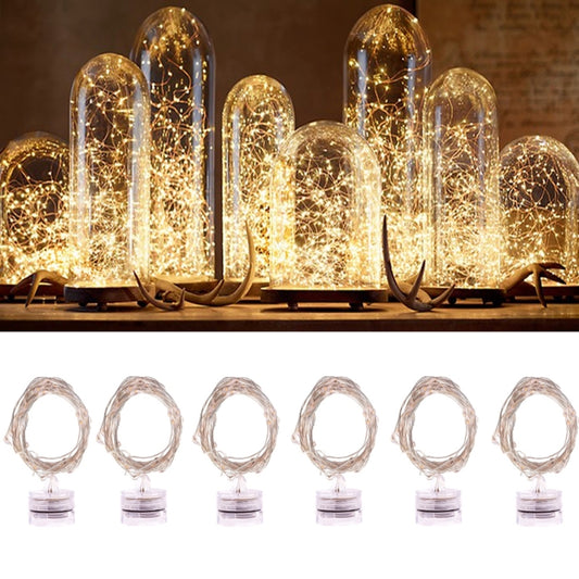 Warm white LED rope fairy lights with lit glass tube bulbs on the ground