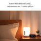 White bedside night light on a bedside table with glowing warm light