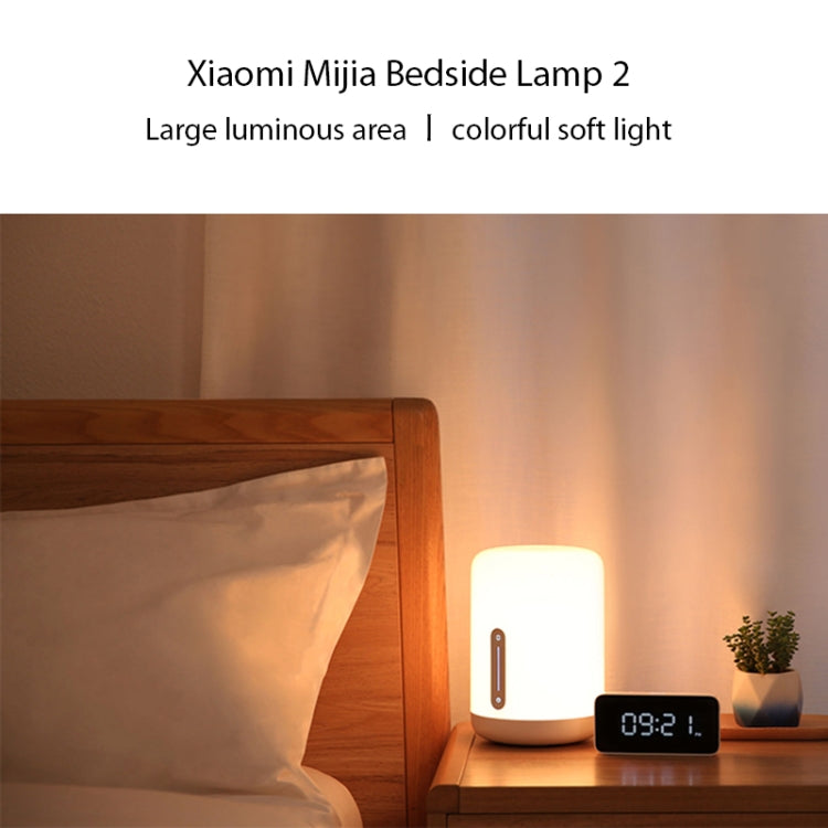 White bedside night light on a bedside table with glowing warm light