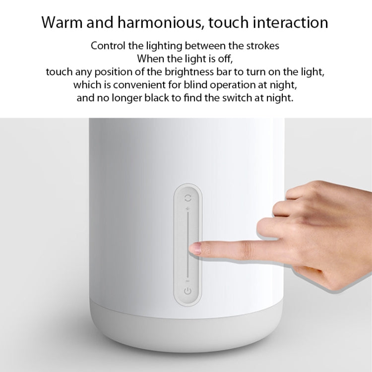 Touchscreen control panel on a white bedside night light lamp, finger pressing