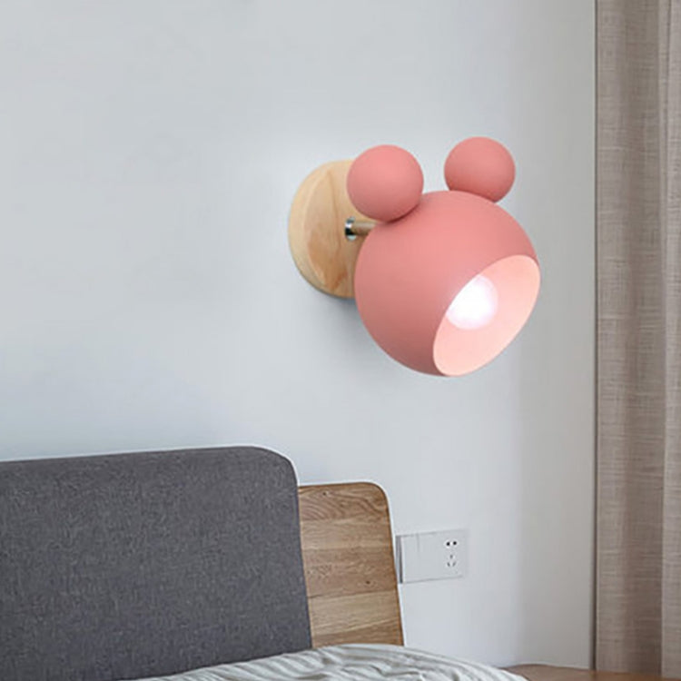 Pink cartoon wall lamp with globe shade, mounted on a wooden backplate