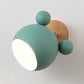 Green cartoon wall lamp with round wooden backplate and globe shades
