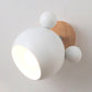 White cartoon wall lamp with globe shade and wooden circular backplate