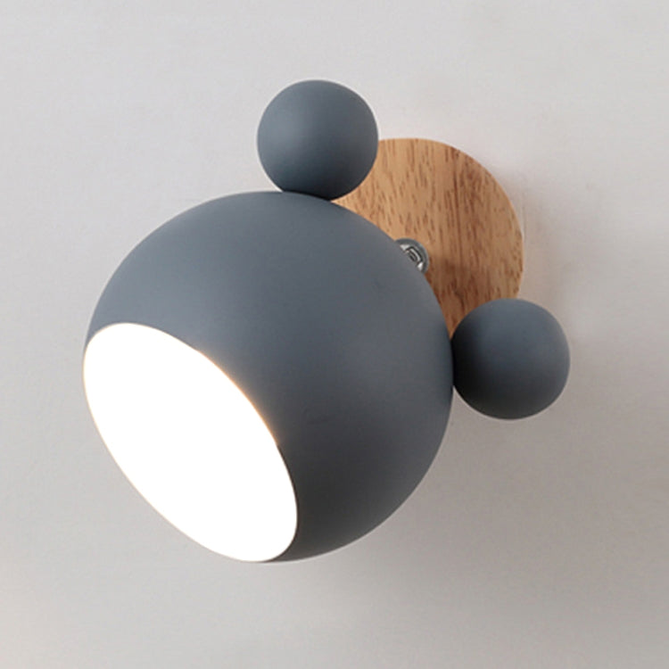 Dark gray round dome wall lamp with wooden backplate and three ball accents, glowing light.