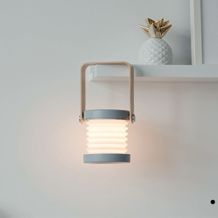 White and wood lantern lamp on shelf, glowing ribbed light base within frame