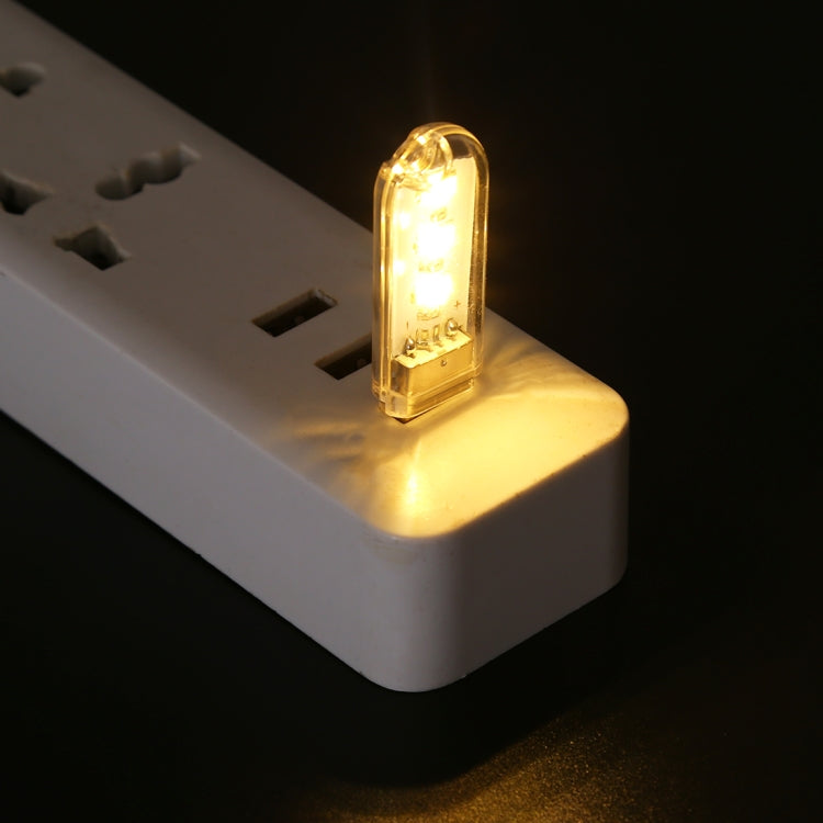 USB LED book light glowing beside an outlet power adapter, warm white light.