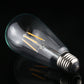 Smoke-gray ST64 LED filament bulb with warm filament bars and E27 screw base.