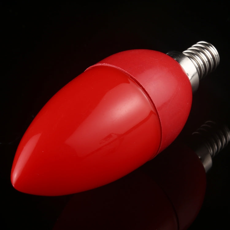Red LED light bulb close-up with metal screw base, smooth teardrop body