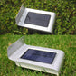 White solar wall light on grass with blue solar panel and base mounting