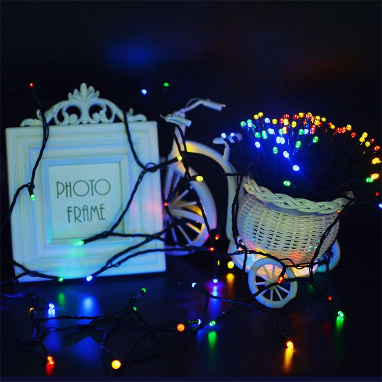 Glowing multicolor LED string lights draped across outdoor decor props