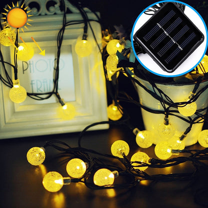 Solar LED bubble ball string lights with warm white globe bulbs on black wire