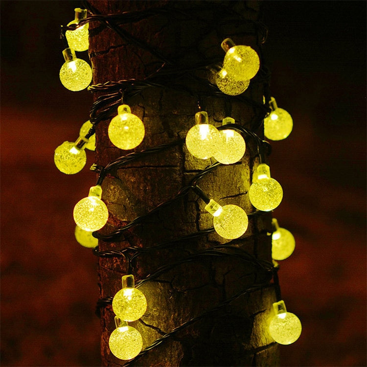Solar LED bubble ball string lights with glowing yellow bubble globes on black cord