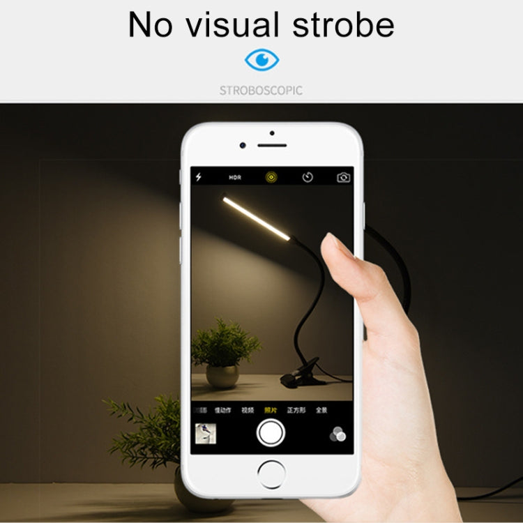 White LED desk lamp controlled by hand on a smartphone screen; no visible strobe.