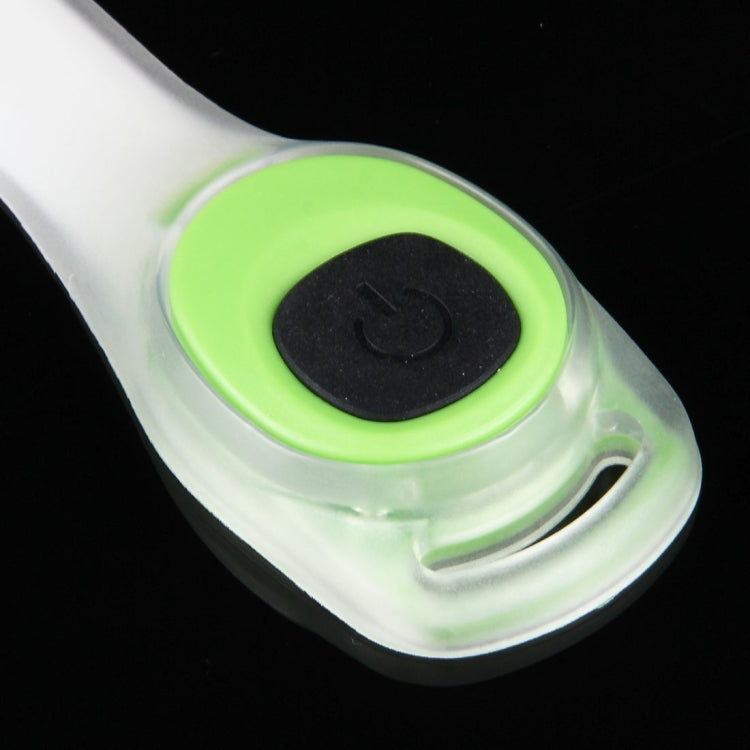 Close-up of green LED light button on white wristband body.