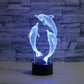 Blue-glowing 3D dolphin LED table lamp with three dolphins on a black base
