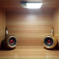 Two installed white motion-sensor LED lights in a wooden cabinet with red indicator