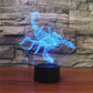 Blue scorpion-shaped LED table lamp with 3D wireframe glow on black base.