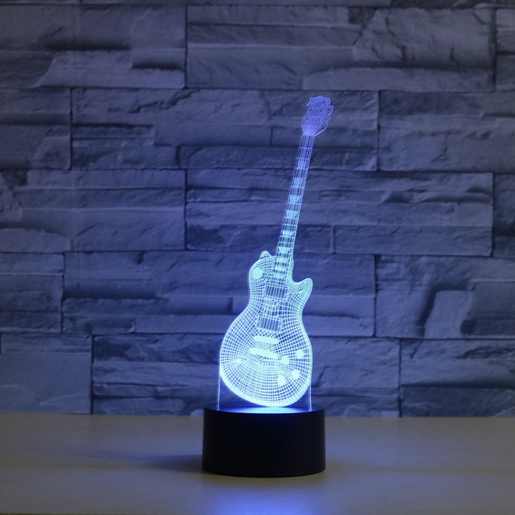 Blue glowing LED guitar-shaped 3D table lamp on a black round base