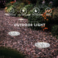 Solar ground LED lights in outdoor garden on gravel, two round heads