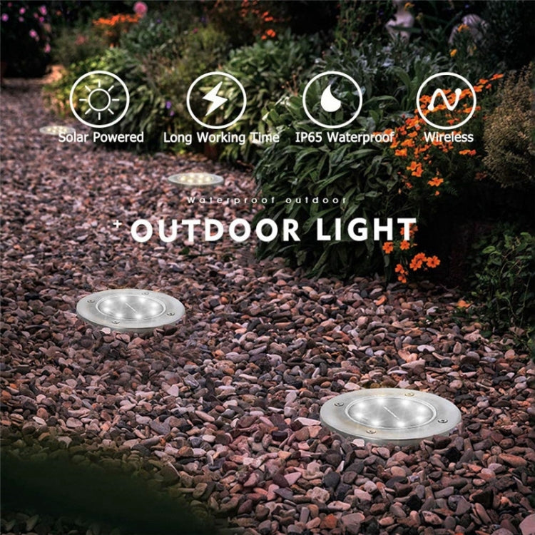 Solar ground LED lights in outdoor garden on gravel, two round heads