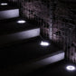 Multiple solar buried ground lights emitting bright white light on steps