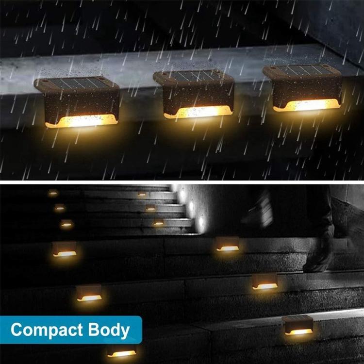 Black solar stair lights in rainfall, warm LEDs glowing on steps and near the wall.