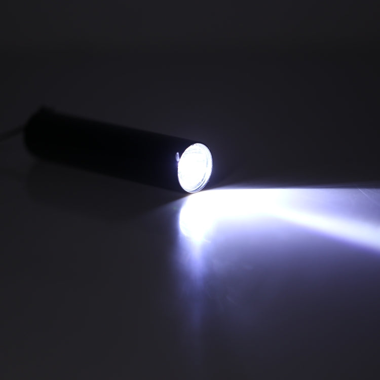 Mini flashlight emitting a strong white beam in a dark setting