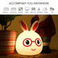 Warm-glow LED rabbit night light glowing yellow with red glasses, smiling face