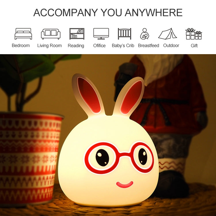 Warm-glow LED rabbit night light glowing yellow with red glasses, smiling face