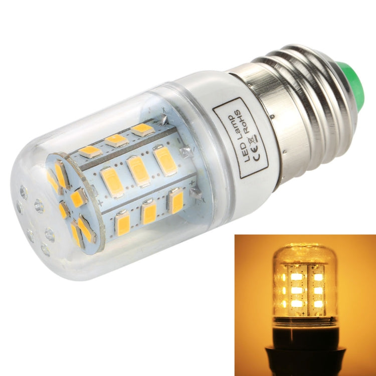 Clear E27 LED bulb with green cap, glowing warm white light inset