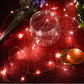 Red LED fairy string lights wrapped around glass bottles and jars, glowing wire strands